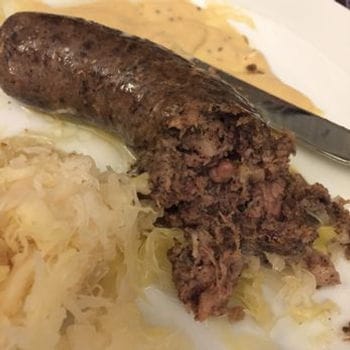 Gross photo of a cut up sausage surrounded by sauerkraut